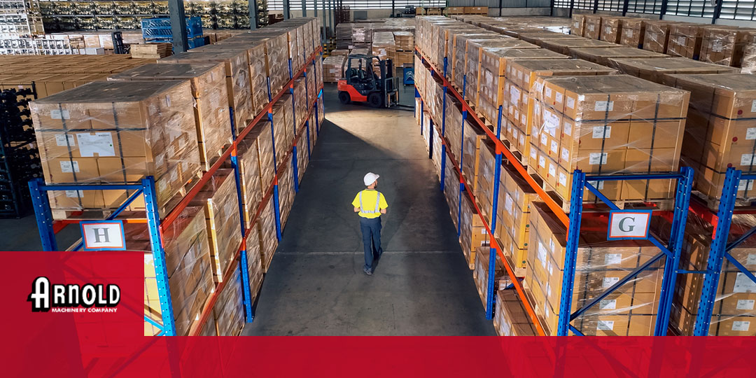 man walking through warehouse towards forklift